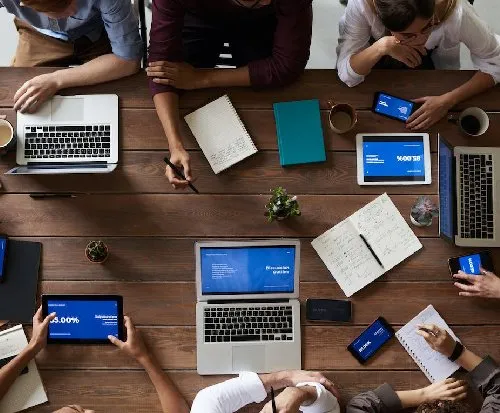 A group of people working around a table, as seen from above